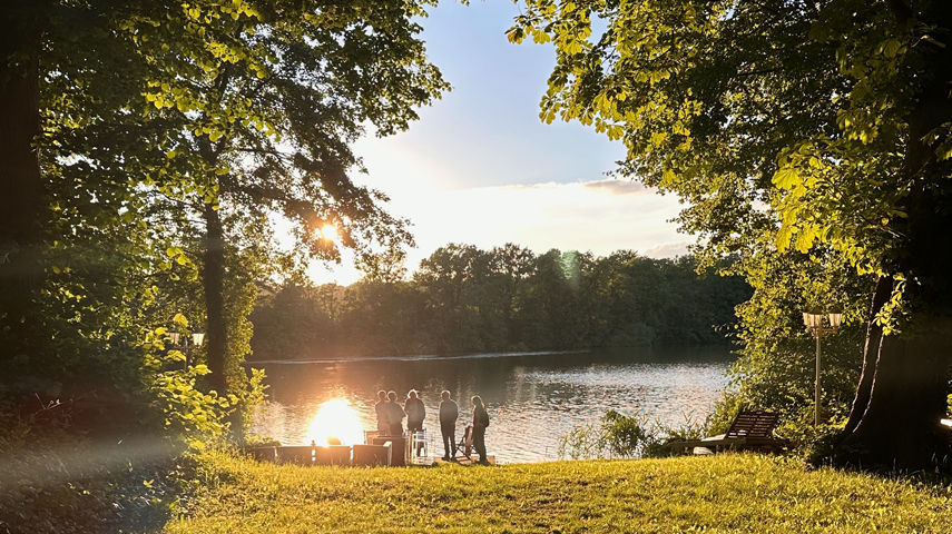 Menschen an einem schönen Teich im Abendlicht