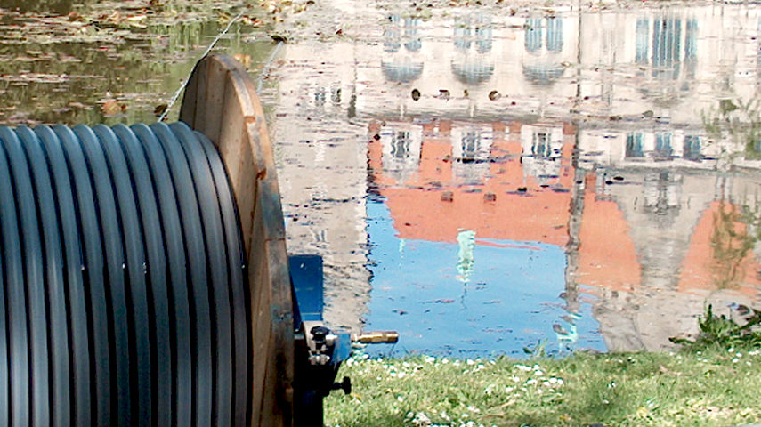 On voit le rouleau de tuyau du système Drausy au premier plan - à l'arrière-plan, le château de Hanovre se reflète dans l'étang de maillage - le système est prêt à être mis en place.